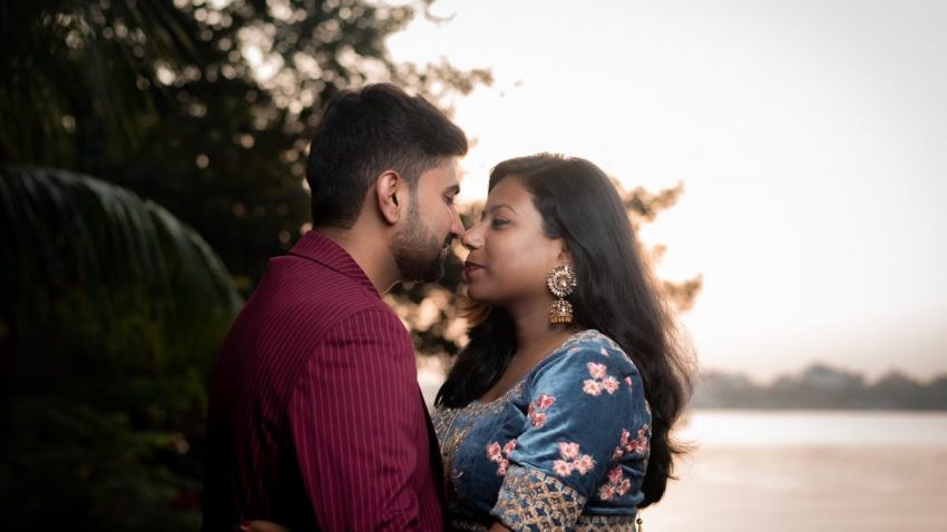Captivating pre-wedding moment with a couple in India by the riverside at sunset.